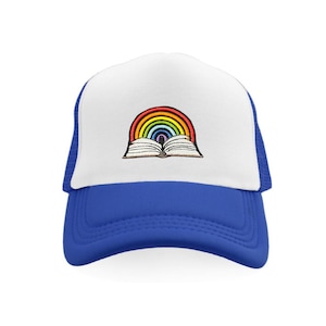 Peut inclure: Un chapeau de camionneur blanc et bleu avec un arc-en-ciel et un livre ouvert. L'arc-en-ciel est composé de rouge, orange, jaune, vert, bleu, indigo et violet.