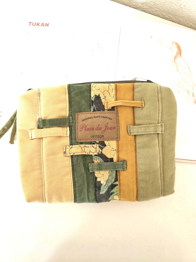 Close-up of denim texture, belt loop detail and floral strip. Shows repurposed materials thoughtfully arranged into one unique padded pouch.