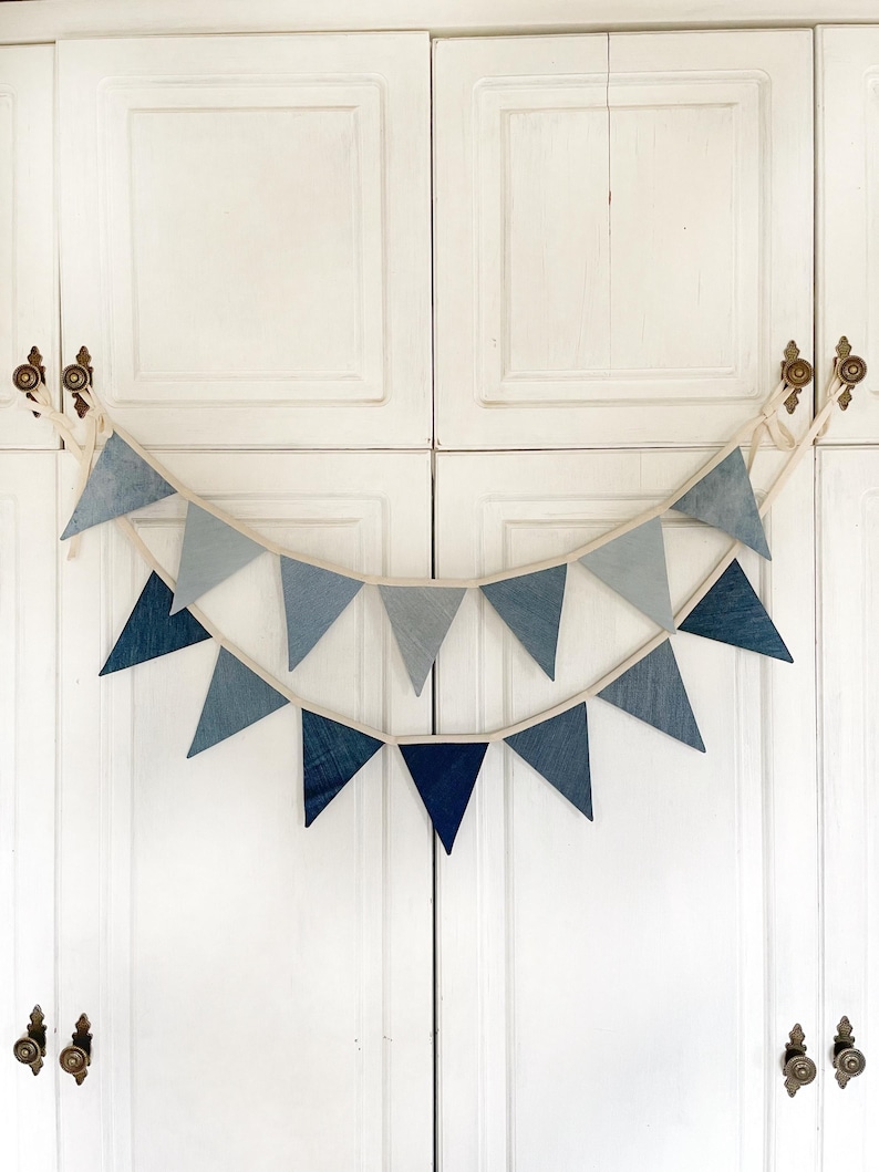 Denim Flags Garland – a handmade denim flag garland, available in light blue or dark blue, adding a touch of rustic charm and sustainable style to your celebration or nursery decor.