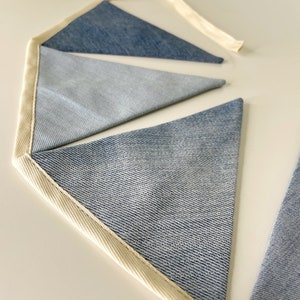 Handmade denim garland will be in various blue tones (from light blue to indigo denim), various textures but similar thicknesses (100% cotton or cotton mixed with spandex) and in various stages of wear.