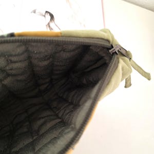 Detail shot of smooth zipper and precise stitching on the upcycled denim pouch. Highlights quality construction, softness and longevity of the design.