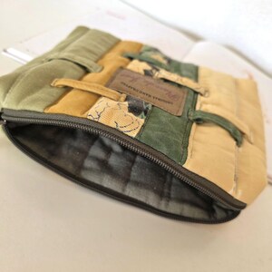 Side angle photo showing the depth and structure of the upcycled denim cosmetic pouch. Reinforced seams and careful tailoring highlight quality, durability and handmade craftsmanship.