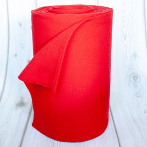 Könnte beinhalten: Eine Rolle leuchtend roten Stoffes, wahrscheinlich für Bastel- oder Nähprojekte.