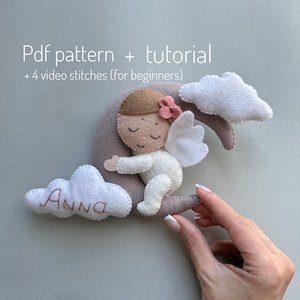 Pu&ograve; includere: Un modello di artigianato in feltro per un angelo addormentato con ali, un fiore rosa e una luna crescente. L'angelo &egrave; su una nuvola con il nome "Anna" ricamato su di essa. Il modello include un modello PDF, un tutorial e quattro punti di cucito in video per principianti.