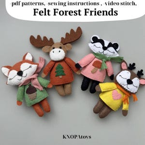 May include: Four felt forest animal toys: a fox, a moose, a badger, and a deer. The fox wears a green coat and pink scarf. The moose has a brown body and antlers. The badger wears a pink coat and green scarf. The deer wears a yellow coat and orange scarf. The text "Felt Forest Friends" is at the top.