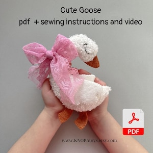 Può includere: Un giocattolo di peluche di oca bianca con un fiocco di pizzo rosa, piedi in feltro marrone e occhi ricamati. Il giocattolo è tenuto dalle mani di una persona. L'immagine include il testo "Cute Goose pdf + sewing instructions and video" e un'icona PDF.