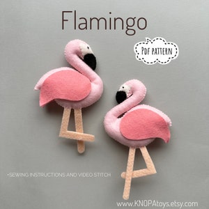 Puede incluir: Dos juguetes de flamenco de fieltro rosa con ojos y picos negros. Los juguetes están de pie sobre un fondo gris claro. El texto "PDF PATTERN" está en un globo de diálogo blanco con un contorno negro discontinuo. El texto "www.KNOPAtoys.etsy.com" está en la parte inferior de la imagen.