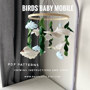 May include: A white, green, and blue felt baby mobile with birds, clouds, and leaves hanging from a wooden ring. The mobile is attached to a white stand. The text "BIRDS BABY MOBILE" is written in white on a black background. The text "PDF PATTERNS + SEWING INSTRUCTIONS AND VIDEO" is written in black on a white background. The text "WWW.KNOPATOYS.ETSY.COM" is written in black on a white background.