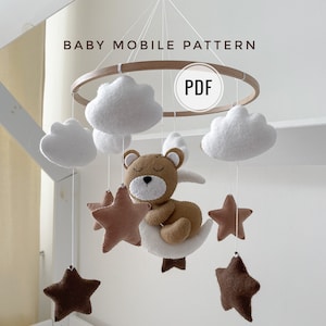 Op de afbeelding: Een PDF-patroon voor een babymobiel met een slapende beer, wolken en sterren. Het patroon bevat naaianwijzingen en vier video-steektutorials voor beginners.