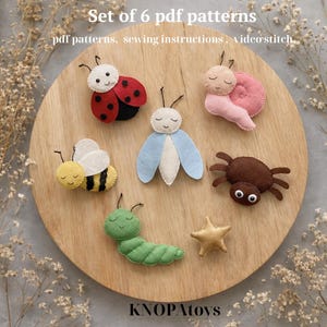 May include: Set of six felt insect patterns, including a ladybug, bee, butterfly, snail, spider, and caterpillar. The insects are arranged on a wooden surface. The text "Set of 6 pdf patterns" is at the top.