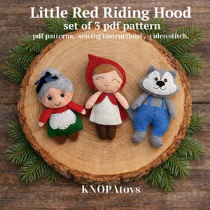 May include: Three felt dolls representing characters from Little Red Riding Hood: the girl in a red cape, the wolf in blue overalls, and the grandmother in a red top and green apron. The dolls are displayed on a wooden slice with text that reads "Little Red Riding Hood".
