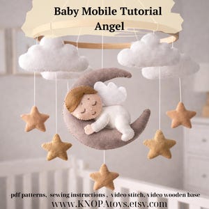 May include: A baby mobile featuring a felt angel sleeping on a crescent moon, surrounded by felt stars and fluffy white clouds. The mobile is suspended from a wooden ring. The text "Baby Mobile Tutorial Angel" is at the top.