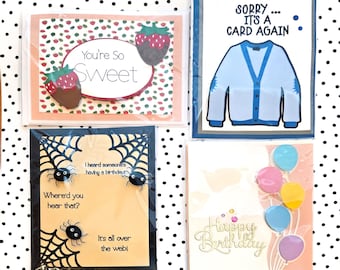 Puede incluir: Cuatro tarjetas de felicitación rectangulares. Una presenta fresas cubiertas de chocolate con el texto 'You're So Sweet'. Otra muestra un cárdigan azul con el texto 'SORRY... IT'S A CARD AGAIN'. Una tercera muestra arañas, telarañas y humor de cumpleaños. La última tiene globos y 'Happy Birthday'.