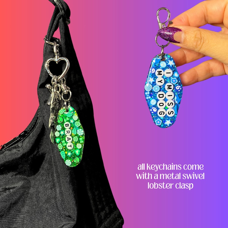 May include: Two keychains with colorful resin charms. One charm is green and says "BRAT" in white letters. The other charm is blue and says "I MISS MY DOG" in white letters. Both charms have a glittery finish.