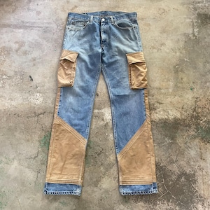 Può includere: Jeans blu con tasche cargo beige e pannelli beige lungo le gambe. I jeans hanno un classico design a cinque tasche e una chiusura con bottone e cerniera. Il denim ha un lavaggio sbiadito.