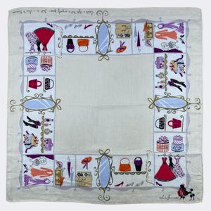 May include: A white cotton square scarf with a colourful print of a shop window display. The print features shoes, purses, hats, dresses, and other accessories. The text "Cooks Shop - 1241 -  Broadway -  New York -  14 -  Gram -  T.E. 2-2241" is printed in the top left corner. The text "Lola by Princess" is printed in the bottom right corner.