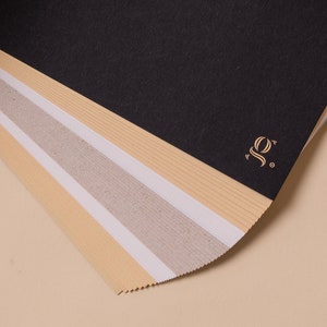 May include: A stack of different colored paper sheets with a gold logo that says "SO." on the top sheet.