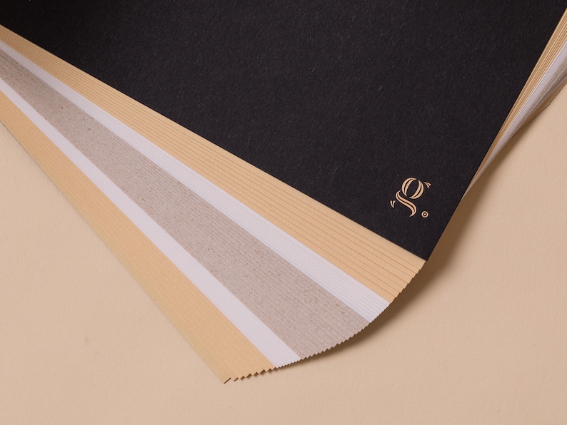May include: A stack of different colored paper sheets with a gold logo that says "SO." on the top sheet.