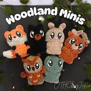 May include: A collection of handmade crochet woodland animal mini plushies. The plushies include a fox, bear, bunny, deer, owl, and turtle. Each plushie has large, expressive eyes and is made with textured yarn. The text "Woodland Minis" is displayed above the plushies.