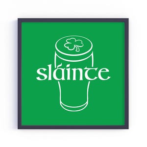K&ouml;nnte beinhalten: Quadratischer gerahmter Druck mit gr&uuml;nem Hintergrund, der eine wei&szlig;e Umrisszeichnung eines Bierkrugs mit einem Kleeblatt oben zeigt. Das Wort "sl&aacute;inte" ist in wei&szlig;er Schrift auf der Vorderseite des Bierkrugs geschrieben.