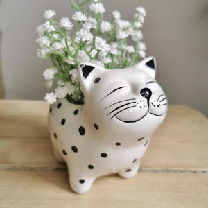 May include: A set of three ceramic nesting bowls in graduating sizes. The bowls are white with a speckled, textured finish and a slightly flared rim. The largest bowl measures approximately 20 cm in diameter.