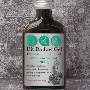 May include: A brown glass bottle with a silver cap, labelled "Dit Da Jow Gel Chinese Liniment Gel (Northern Shaolin)". The label includes text about stimulating circulation and reducing pain. The bottle contains 200ml.