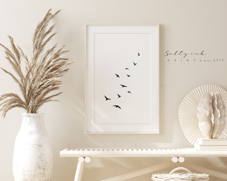 Peut inclure: Une impression minimaliste en noir et blanc d'un vol d'oiseaux en formation. L'impression est encadr&eacute;e dans un cadre blanc et est accroch&eacute;e &agrave; un mur blanc. Le texte "Saltyink Prints on Etsy" est visible dans le coin sup&eacute;rieur droit de l'image.