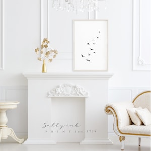 Peut inclure: Une impression en noir et blanc d'un vol d'oiseaux en formation sur un fond blanc. L'impression est encadr&eacute;e et accroch&eacute;e &agrave; un mur blanc au-dessus d'une chemin&eacute;e blanche.
