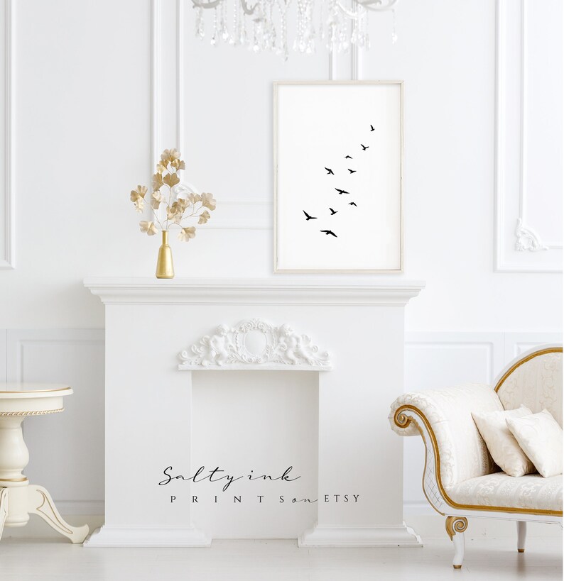 Peut inclure: Une impression en noir et blanc d'un vol d'oiseaux en formation sur un fond blanc. L'impression est encadr&eacute;e et accroch&eacute;e &agrave; un mur blanc au-dessus d'une chemin&eacute;e blanche.