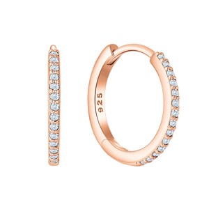 May include: A pair of rose gold hoop earrings featuring a row of small, clear, round-cut stones set along the front edge. The metal surface is smooth and polished, and the inner side of one hoop is clearly stamped with the hallmark 925.