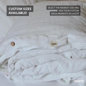 May include: White linen bedding set, folded and stacked. The set includes a duvet cover with a wooden button closure and a small tag that reads "Linen Spree". Text on the image says "Custom Sizes Available!" and "Select the nearest size and add your custom measurements in a note."