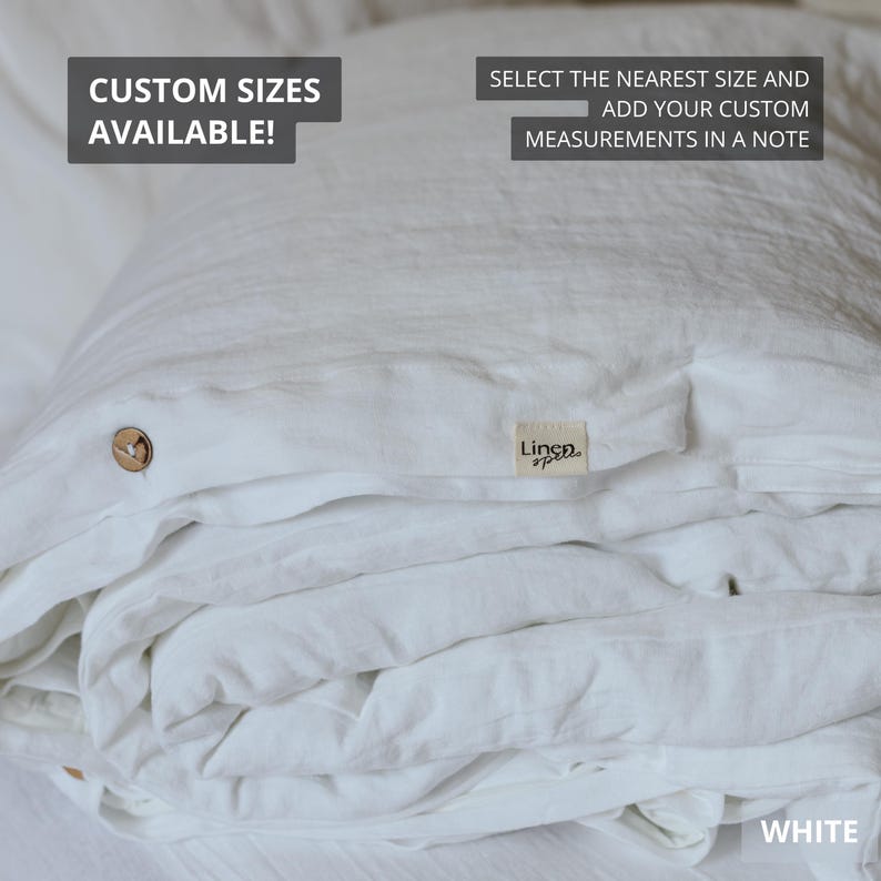 May include: White linen bedding set, folded and stacked. The set includes a duvet cover with a wooden button closure and a small tag that reads "Linen Spree". Text on the image says "Custom Sizes Available!" and "Select the nearest size and add your custom measurements in a note."