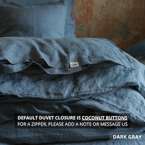 May include: Dark gray linen bedding set, including a duvet cover and pillowcases. The duvet cover features coconut buttons and a small white tag with the brand name. The text on the image reads "DEFAULT DUVET CLOSURE IS COCONUT BUTTONS FOR A ZIPPER, PLEASE ADD A NOTE OR MESSAGE US DARK GRAY."