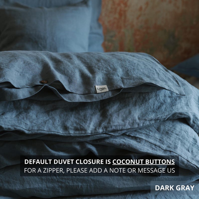 May include: Dark gray linen bedding set, including a duvet cover and pillowcases. The duvet cover features coconut buttons and a small white tag with the brand name. The text on the image reads "DEFAULT DUVET CLOSURE IS COCONUT BUTTONS FOR A ZIPPER, PLEASE ADD A NOTE OR MESSAGE US DARK GRAY."