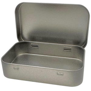 May include: A rectangular silver-colored metal tin with a hinged lid. The container features rounded corners and a smooth, metallic finish. The lid is open, revealing the hollow interior of the box, which is constructed from the same brushed metal material.