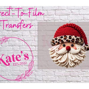 May include: A festive Santa Claus face with a red knit hat, leopard print trim, and a long white beard. The image includes the text "Direct-To-Film Transfers" and "Kate's EST. 2022" in a pink circle with a floral design.