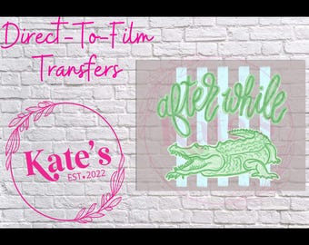 May include: Direct-To-Film Transfers graphic with the text "after while" above a green alligator illustration. The image includes a pink circle with the text "Kate's EST. 2022" and a floral design.