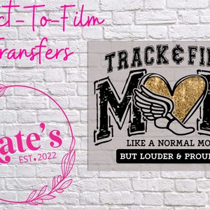 May include: Black and gold graphic design with the text "TRACK & FIELD MOM" and the words "LIKE A NORMAL MOM BUT LOUDER & PROUDER".