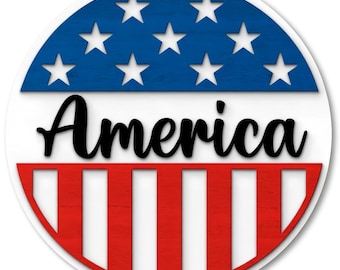 May include: A round, patriotic design featuring the word "America" in black script. The top half is blue with white stars, and the bottom half has red and white stripes, evoking the American flag.