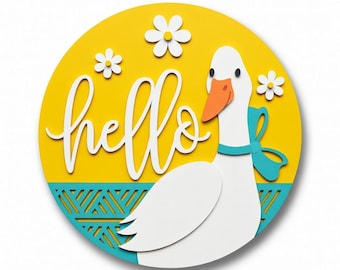 May include: A round, yellow wooden sign with a white goose and the word "hello" in cursive. The goose has a blue bow and an orange beak. White daisies are scattered around the sign. The bottom of the sign has a blue geometric pattern.