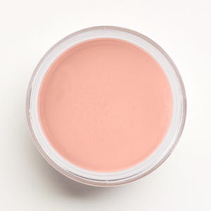 May include: A small, round jar of light pink cream blush.