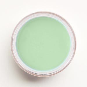 May include: A small, round jar of green-colored face primer.
