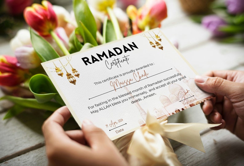 May include: A certificate with a gold and white design, featuring a mosque and lanterns. The text "RAMADAN Certificate" is at the top, and the text "This certificate is proudly awarded to: Maissa Chad" is below. The text "For fasting in the blessed month of Ramadan successfully May ALLAH bless you immensely, and accept all your good deeds, Ameen." is in the middle of the certificate. The text "11 Apr 2004" is at the bottom of the certificate.