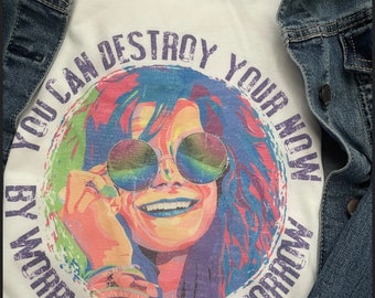May include: White t-shirt with a colorful graphic of a woman wearing sunglasses and the text "You can destroy your now by worrying about tomorrow."