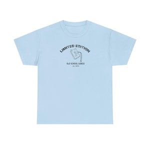 May include: Light blue t-shirt with a black graphic of a vintage video game cartridge and the text "Limited Edition Old School Gamer - est. 1970 - "