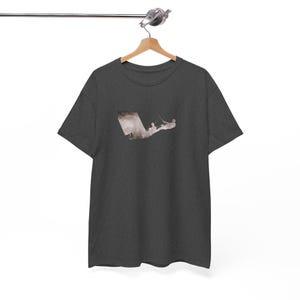 May include: A dark heather grey t-shirt with a silhouette of a person kitesurfing. The silhouette is in shades of brown and white.