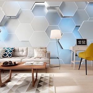 May include: A modern living room featuring a grey sectional sofa, a wooden coffee table, a yellow chair, a white desk, a lamp, and a bookcase filled with books. The wall behind the sofa is decorated with a geometric pattern of white and blue hexagons. A clock on the desk displays 12:52.
