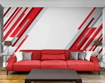 May include: A contemporary living room with a red sofa, grey and white cushions, and a dark brown coffee table. The wall is decorated with red and grey diagonal stripes on a white background. Side tables with lamps.