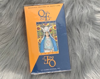May include: A blue and orange box with the text "Quick & Easy Tarot" and a picture of a tarot card with a woman in a blue robe and a white crown. The text "U.S. Games Systems, Inc." is printed on the bottom of the box.