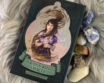 May include: A black and green book with a decorative border and a woman holding a wand on the cover. The title of the book is "Raven's Wand Oracle" by Steven Hutton.